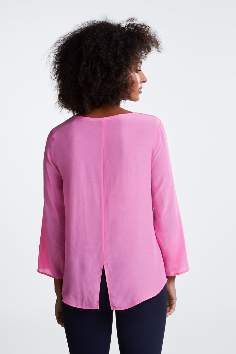 Bright pink top with 3/4 sleeves and dipped hem