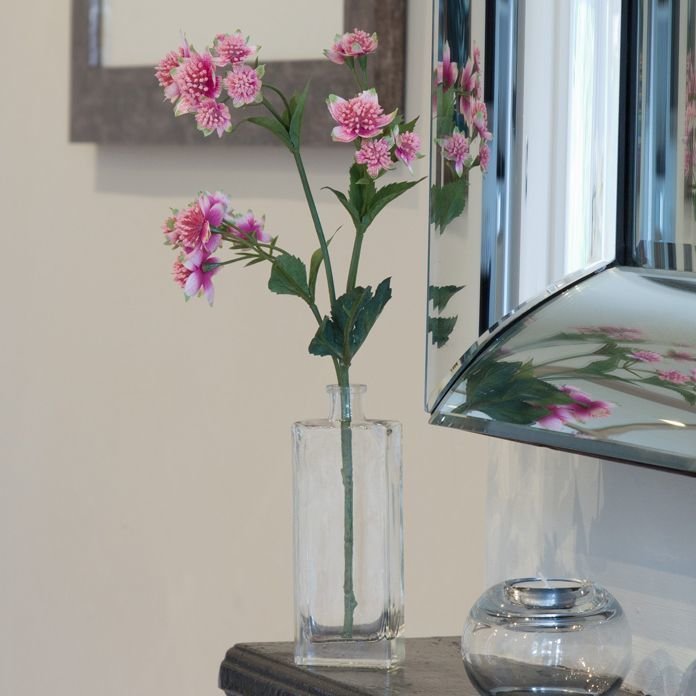 Artificial pink astranthia spray in a Genny bottle vase Artificial pink astranthia spray in a Genny bottle vase