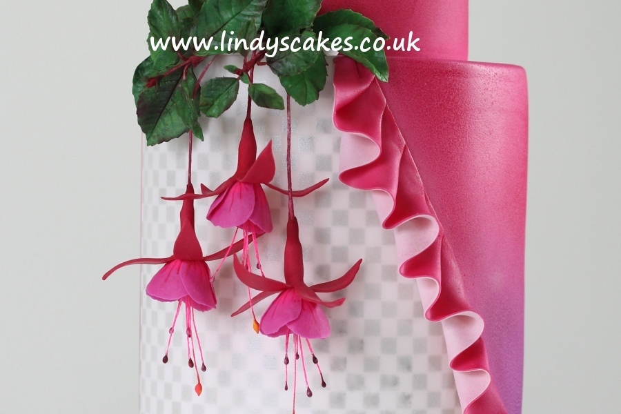 Beautiful life-like sugar fuchsias hanging down the sides of a wedding cake