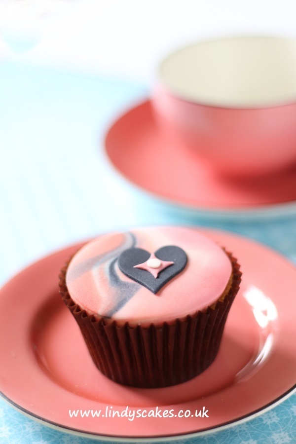A striking black sugar heart on marbled sugarpaste makes a fabulously simple decoration for a cupcake. The heart cutter used comes from Lindy's card suit sugarcraft cutter set