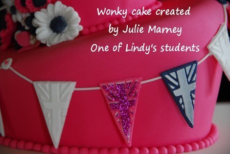 Lindy's bunting cutter used to create a string of bunting to attractively decorate the side of this striking pink cake