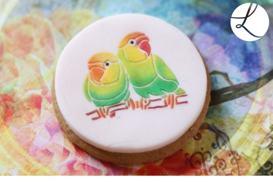 a pair of lovebirds in greens yellows and oranges - a wonderful bright cookie decoration