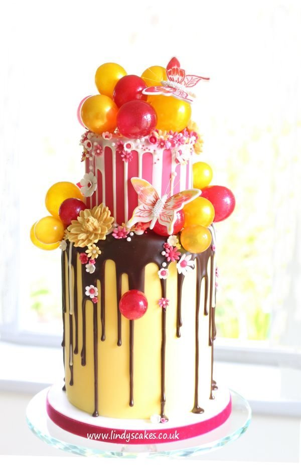 Large butterfly stencil used with Lindy's butterfly cutter to create two dainty butterflies to adorn this pink and yellow chocolate drip cake