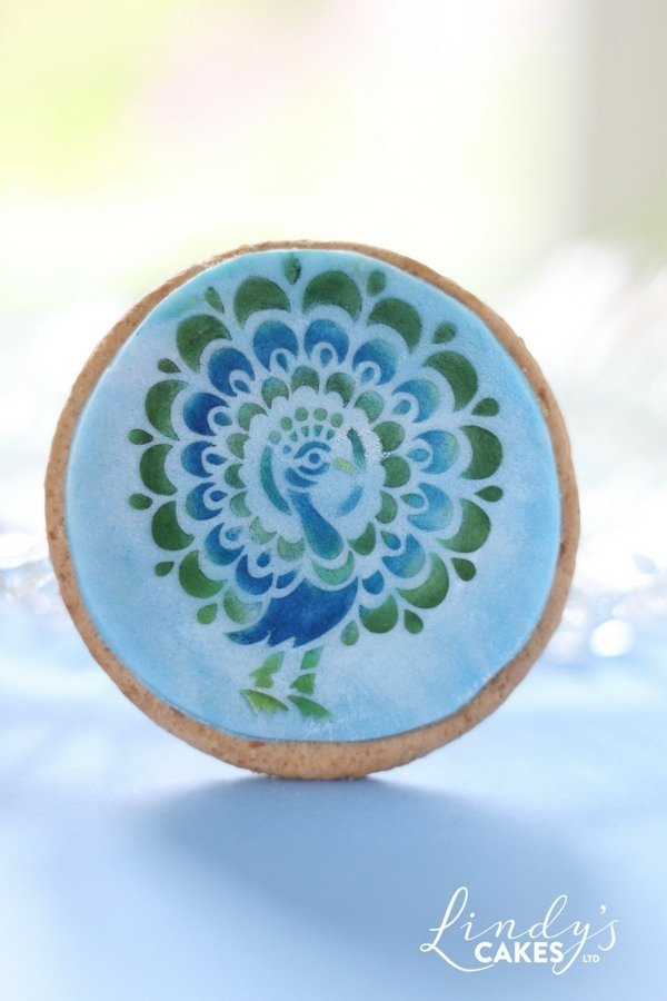 Blue peacock stenilled onto a round cookie
